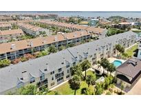 Scenic aerial view of waterfront condos with lush landscaping, balconies, and a community pool at 443 Pinellas Bayway S # 105, Tierra Verde, FL 33715