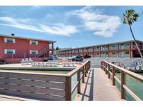 Waterfront lodging with multiple units and an outdoor dining area on a sunny day at 8565 W Gulf Blvd # 17S, Treasure Island, FL 33706