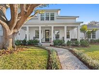 Charming two-story home with a welcoming porch, swing, beautiful landscaping, and a brick walkway at 120 25Th N Ave, St Petersburg, FL 33704