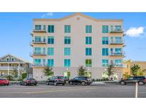 Modern six story condo building with balconies, manicured landscaping, and street parking at 644 3Rd S Ave # 305, St Petersburg, FL 33701