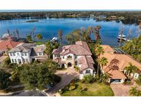Stunning waterfront home boasts a clay tile roof, circular driveway, and lush landscaping at 1903 Haven Bend, Tampa, FL 33613