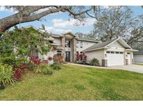 Stunning two story home featuring mature landscaping and an attached two car garage at 363 Sanctuary Dr, Crystal Beach, FL 34681