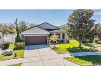Charming single-story home with well-manicured lawn and a two-car garage at 714 Sugar Camp Way, Brooksville, FL 34604