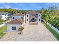 Elegant two-story home featuring a tile roof, brick driveway, portico entry, and lush landscaping at 9401 93Rd St, Seminole, FL 33777