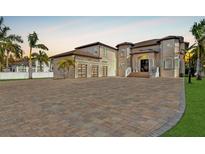 Elegant two-story home with a three-car garage, beautifully landscaped yard, and a spacious brick driveway at 9401 93Rd St, Seminole, FL 33777