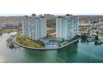 Waterfront condominium complex with towers, a pool, tennis court, and lush landscaping on a peninsula at 420 64Th Ave # 1005, St Pete Beach, FL 33706