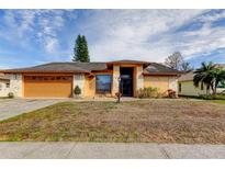 Charming single-story home with stone accents, a two-car garage, and landscaped front yard at 4728 Swallowtail Dr, New Port Richey, FL 34653