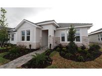 Charming single-story home featuring stone accents, well-maintained landscaping, and a paved walkway to the front door at 695 Allora Ave, Nokomis, FL 34275