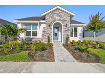 Beautiful one-story home featuring stone accents, manicured landscaping, and a welcoming blue front door at 687 Allora Ave, Nokomis, FL 34275