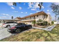 Inviting condo building with balcony access, attractive landscaping, and assigned parking spaces at 9945 47Th N Ave # 206, St Petersburg, FL 33708