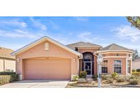 Charming single-story home featuring a two-car garage and a well-maintained front yard with beautiful landscaping at 1330 Misty Greens Dr, Sun City Center, FL 33573