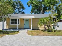 Charming single-story home featuring a walkway to a quaint, light-blue front door and freshly painted yellow siding at 2619 Miriam S St, Gulfport, FL 33711