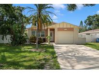 Charming single-story home with a well-maintained lawn, mature landscaping, and an attached garage at 651 Southwest N Blvd, St Petersburg, FL 33703