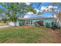 Charming single-story home with a manicured lawn and lush landscaping at 13851 102Nd Ave, Largo, FL 33774