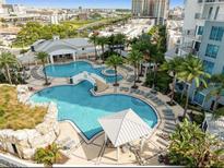 Stunning aerial view of a community pool with palm trees and a charming bridge at 1209 E Cumberland Ave # 505, Tampa, FL 33602