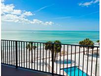 Expansive beach view featuring palm trees and a pool from a balcony overlooking the ocean at 16330 Gulf Blvd # 306, Redington Beach, FL 33708