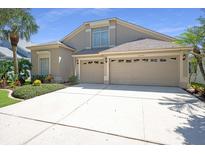 Two-story home featuring an attached three-car garage and spacious driveway at 15555 Martinmeadow Dr, Lithia, FL 33547