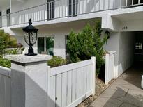 Inviting condo entrance with a white fence, featuring manicured greenery and walkway access at 1655 S Highland Ave # J193, Clearwater, FL 33756