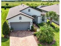 Charming single-Gathering home featuring a well-manicured lawn, brick driveway, and two-car garage at 4748 Ballast Crest Cv, Land O Lakes, FL 34638