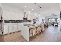 Bright kitchen boasts white cabinets, stainless appliances, and a large island with seating at 11721 1St E St, Treasure Island, FL 33706