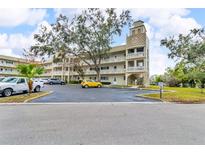 Three-story condominium building featuring balconies, a unique tower, and well-maintained parking area at 2351 Irish Ln # 21, Clearwater, FL 33763
