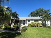 Charming single-story home with lush landscaping, manicured lawn and inviting front entrance at 5730 16Th Ne Ln, St Petersburg, FL 33703