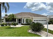 Charming single-story home featuring a well-manicured lawn, two car garage and welcoming screened in porch at 1311 Caloosa Lake Ct, Sun City Center, FL 33573