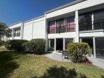 Exterior view of a two-story condo with a balcony, patio, and well-maintained lawn at 2060 Marilyn St # 133, Clearwater, FL 33765