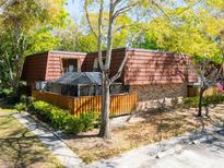 Charming two-story home with a brick facade, a wood fence, and lush landscaping adding to its curb appeal at 2730 5Th Ct, Palm Harbor, FL 34684