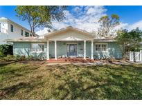 Charming blue brick home featuring a covered front porch with white columns and decorative glass front door at 710 S Davis Blvd, Tampa, FL 33606