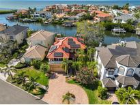 Waterfront home featuring a red tile roof, solar panels, and lush tropical landscaping with water access at 1011 Sonata Ln, Apollo Beach, FL 33572