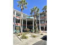 A multi-story condominium building features a beautiful entry and surrounding landscaping at 4300 58Th N St # 1909, Kenneth City, FL 33709