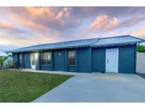 Charming single-story home with a well-maintained lawn, long driveway, and metal roof at 5108 Redwood Ter, North Port, FL 34286