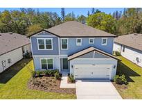 Two story home with gray siding and a two car garage at 1255 Kazaz Ct, Zephyrhills, FL 33540