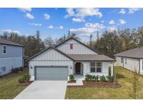 Charming single-story home featuring a gray exterior, well-manicured lawn, and an attached two-car garage at 1267 Kazaz Ct, Zephyrhills, FL 33540