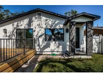 Charming home with a well-manicured lawn, stone columned entryway, and inviting wooden deck at 2835 Freemont S Ter, St Petersburg, FL 33712