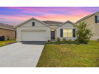 Charming single-Gathering home featuring a well-manicured lawn, a two car garage, and beautiful landscaping at 11976 Brighton Knoll Loop, Riverview, FL 33579