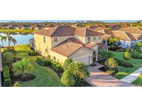 Stunning two-story home with a beautiful tile roof, lush landscaping, and waterfront views at 6467 Willowshire Way, Bradenton, FL 34212