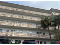 Multi-story condo building featuring balconies with decorative privacy screens and mature palm trees at 5603 80Th N St # 512, St Petersburg, FL 33709