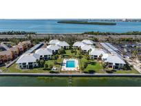 Beautiful aerial view of waterfront condos with a pool, dock, and stunning bay views at 7300 Sunshine Skyway S Ln # 202, St Petersburg, FL 33711