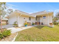 Charming single-story home featuring well-maintained landscaping, a welcoming entrance, and attached garage at 1007 Lake Avoca Dr, Tarpon Springs, FL 34689
