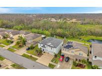 A high angle view of a two-story home with a large driveway and well-maintained landscaping in a suburban neighborhood at 5045 Ivory Stone Dr, Wimauma, FL 33598