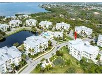 Beautiful aerial view of the condo complex near a lake with multiple buildings and lush greenery at 7611 34Th W Ave # 303, Bradenton, FL 34209