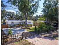 Charming single-story home featuring solar panels, a gravel driveway, and lush landscaping enhancing curb appeal at 3087 Duane Ave, Oldsmar, FL 34677