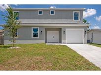 Two-story home featuring a gray exterior, a well-manicured lawn, and an attached single-car garage at 3801 Luma Dr, Holiday, FL 34691