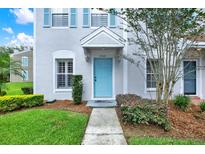 Charming home featuring a light blue front door and light blue shutters in a well manicured landscape at 8541 Hunters Key Cir, Tampa, FL 33647