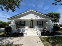 Charming home featuring a white exterior with blue accents, complemented by a well-manicured front yard at 14124 Plum Ln, Hudson, FL 34667