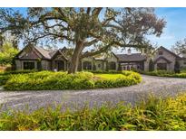 Stately home with meticulous landscaping, mature trees, and circular driveway provides an inviting curb appeal at 3005 S Miller Rd, Valrico, FL 33596
