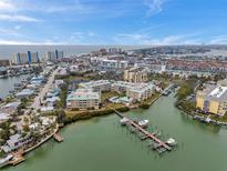 Beautiful aerial view of waterfront condos with docks and a pool, near the ocean and city at 399 150Th Ave # 101, Madeira Beach, FL 33708