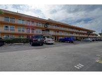 Three-story condo building featuring balconies, multiple parking spaces and well-maintained landscaping at 6400 46Th N Ave # 307, Kenneth City, FL 33709